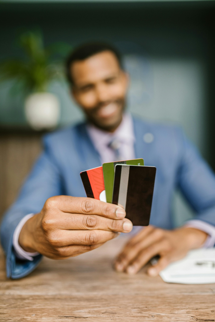 a man in a suit holding up credit cards