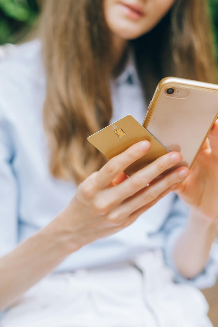 a woman holding her credit card and her phone