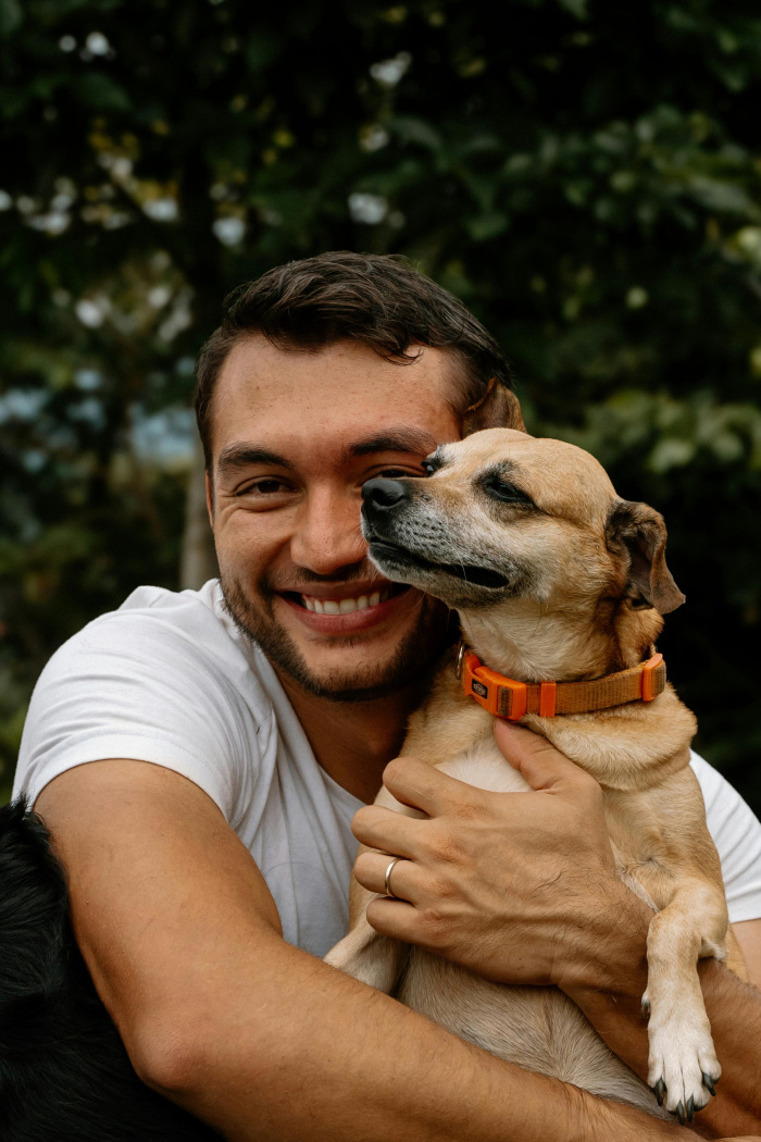 a man holding his dog and smiling