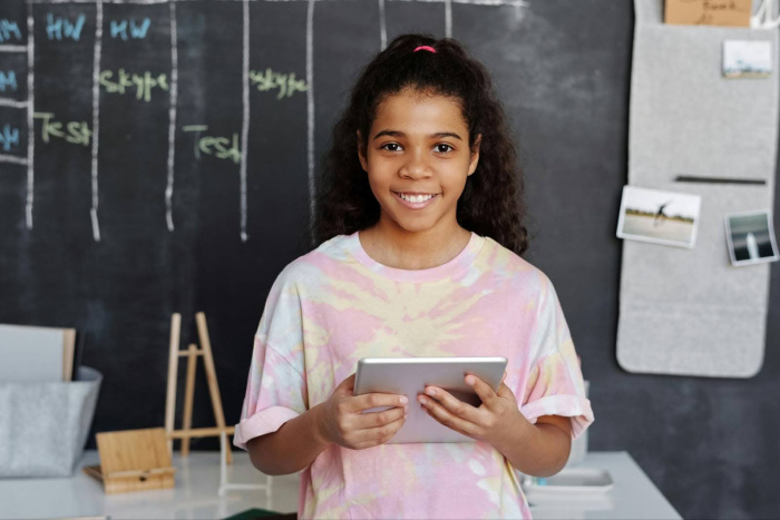 a young girl in a classroom with a tablet