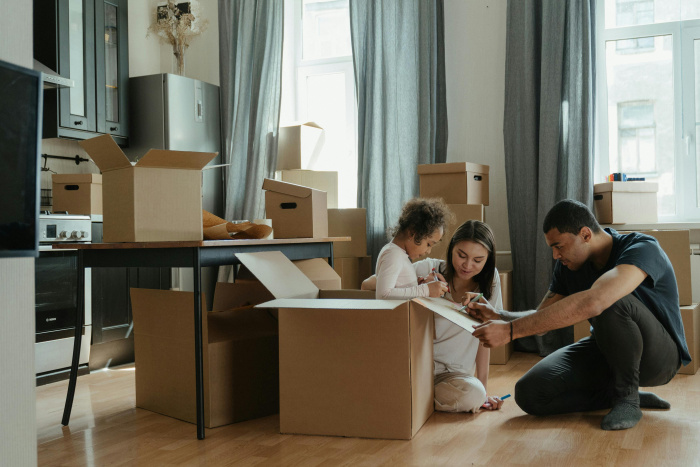 a family packing boxes together preparing to move into a new home