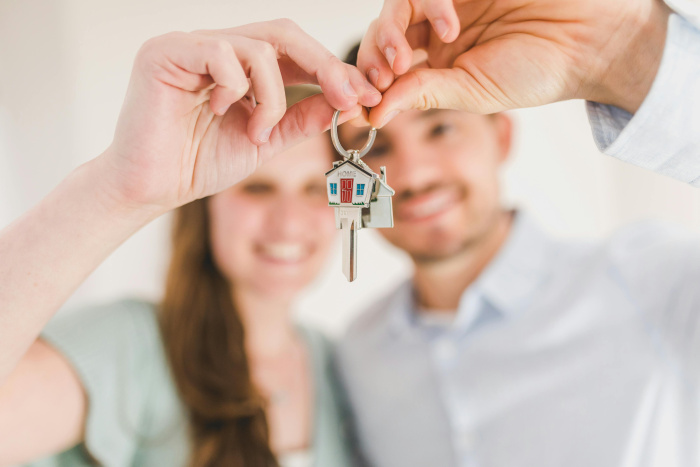 a couple holding uip keys to their first home