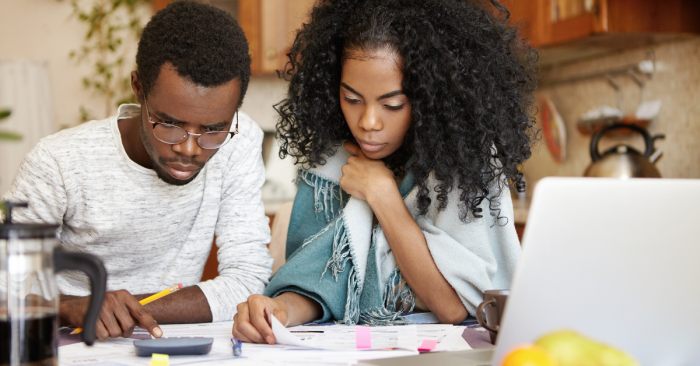 a couple looking over expenses and calculating an ideal mortgage payment and cost for their home