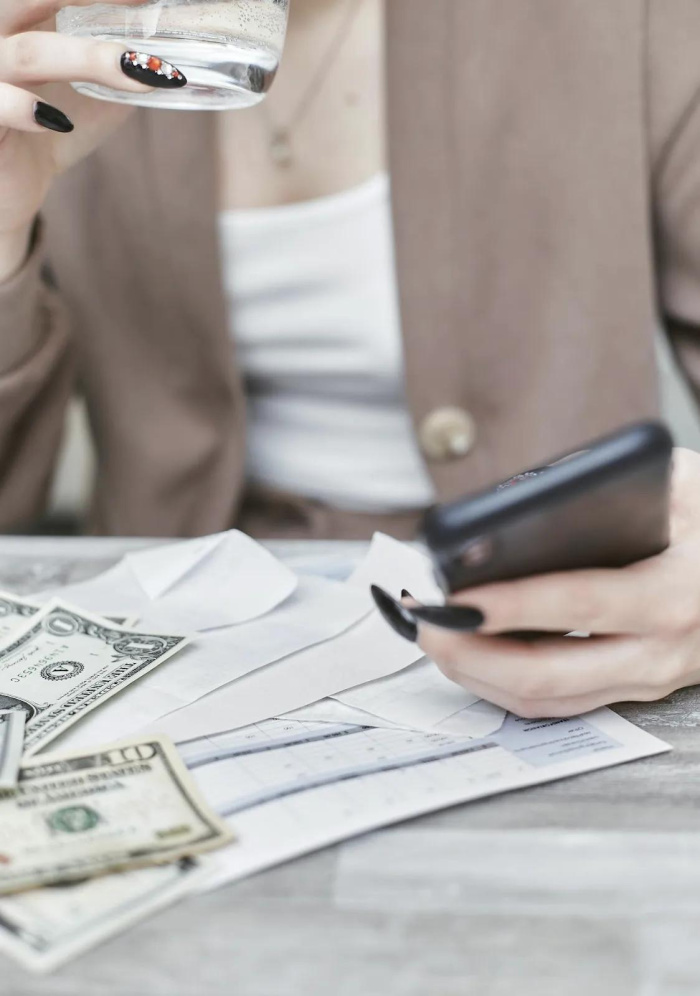 Checking Accounts in Baton Rouge - a woman on her phone with money in front of her