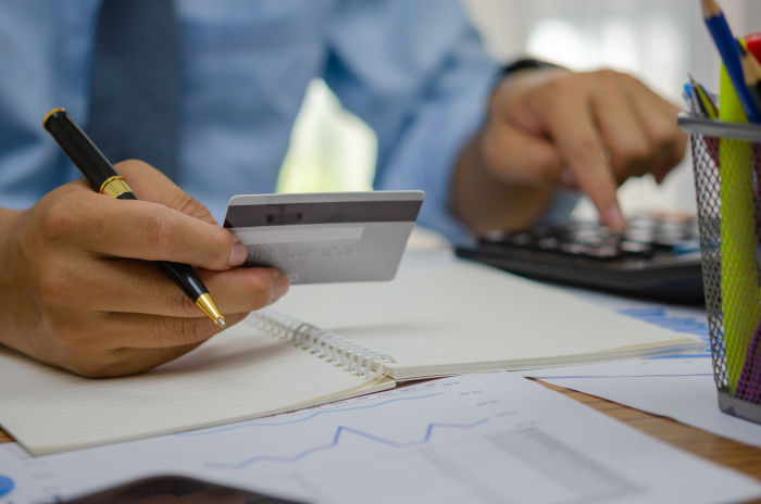 Member of Essential Credit Union in Walker looking at his checking account card and other paperwork on a desk
